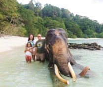 Zoom image: Flor, Maya and Rob Martin next to Rajan, a 63-year-old elephant who knew how to swim, Barefoot Resort, Havelock Island in the Andaman Islands, India, December 2013. (Photo courtesy Rob Martin) 
