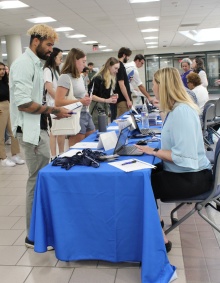 Orientation check in students and staff at a table. 