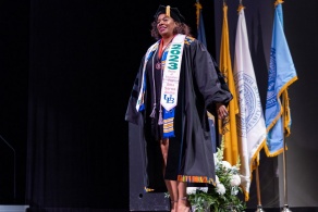 Zoom image: Ebony Bullock accepting the Excellence in Equity, Diversity, Justice and Inclusion Award at the 2023 commencement ceremony. 