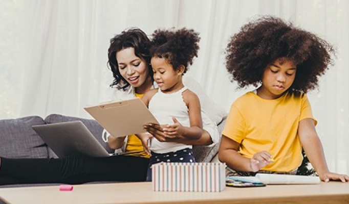 Mom working from home teaching two children. 