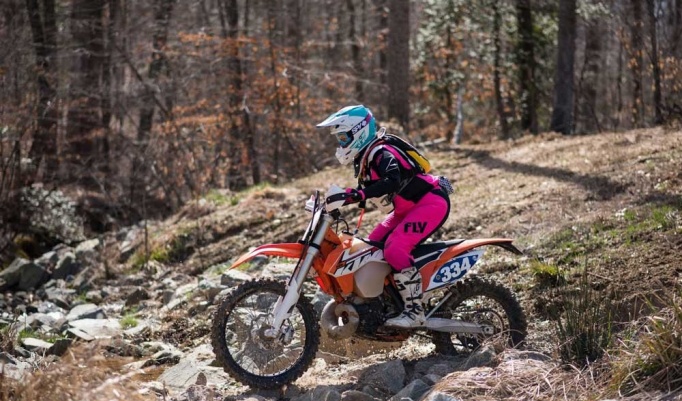Amanda Knapp riding her motorcycle in outdoor terrain. 