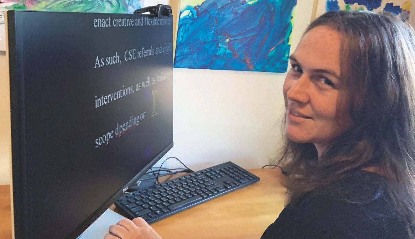 Image of Kathleen Reeb-Reascos sitting at a computer.