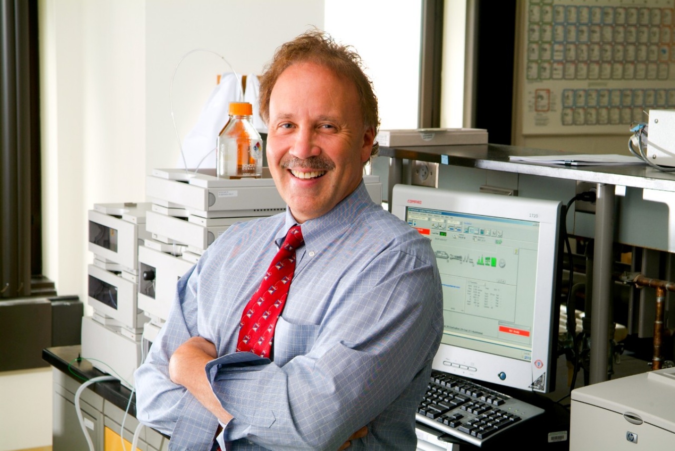 Gene Morse in front of lab equipment.