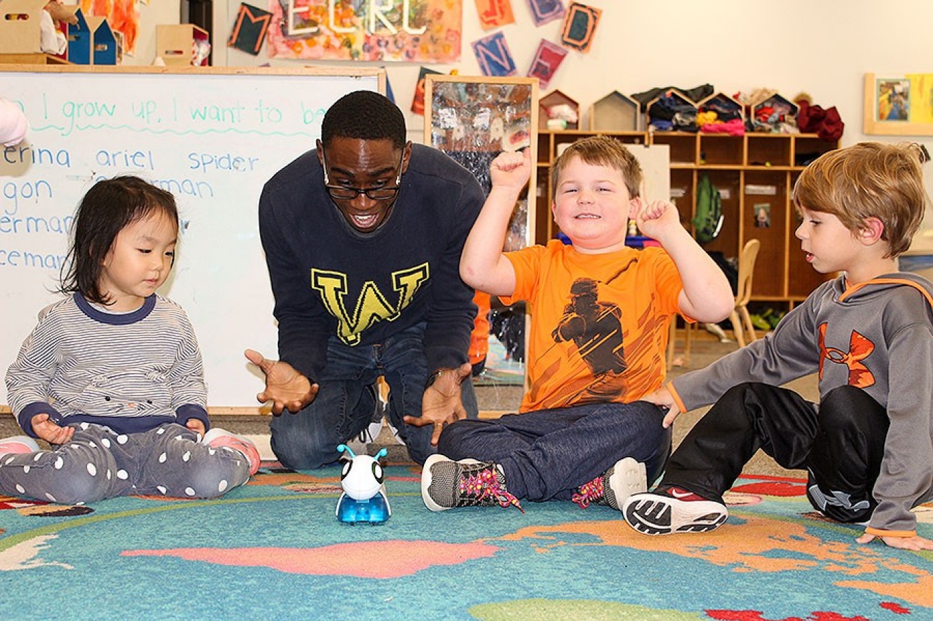An excited Lochlan Schlader watches as the code-a-pillar With him are teacher Stanley Diih and Janice Leong and Griffin Maines.