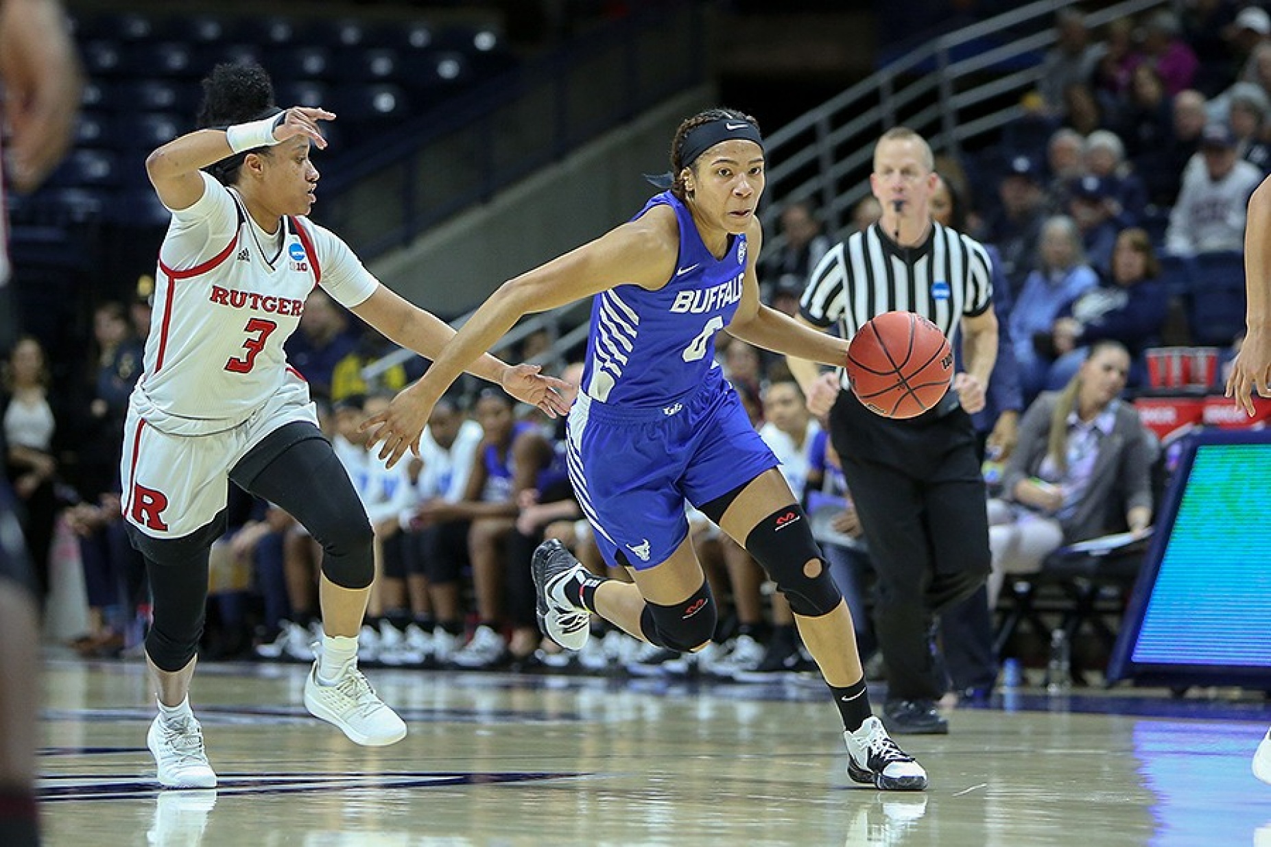 Summer Hemphill dibbles the ball down the court while blocking a Rutgers player.