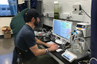 Recent graduate Justin Bracci programs the cultivation system used to grow the group’s own algae in the lab. 