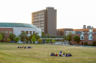 Small groups sit in the Special Events Field near the Student Union.