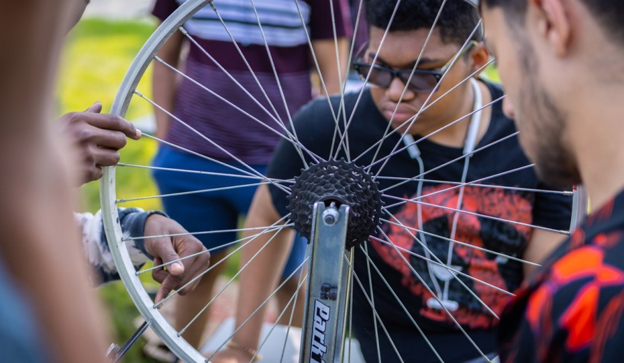 Students working on a bicycle. 