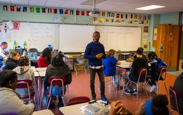 Teacher teaching a lesson to a class of middle school children. 