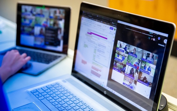 Laptop screens showing active Zoom sessions. 