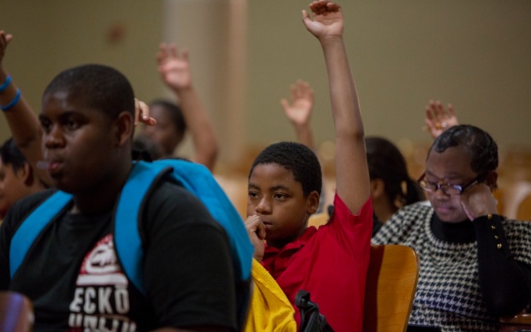 Students raising hands. 