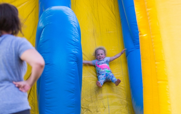 Kenedy Stockwell (right) enjoys the slide with her mother, Jessica Stockwell, at UB on the Green on July 19, 2017. Featuring Randle and the Late Night Scandals, this night is dedicated to health in the community with free health screenings provided by UBMD, UB Nursing and UB Dental, and fun activities for the children. Photographer: Meredith Forrest Kulwicki. 