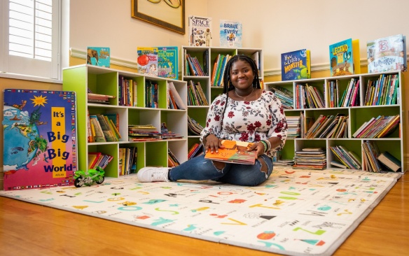 Mirna Cadet is photographed in the reading area she and fellow members of Team Traffic Cones created in the women and children's shelter in the Buffalo City Mission in June 2023. The group collected more than 1,000 books which were donated to the women’s and men’s shelters. Photographer: Meredith Forrest Kulwicki. 