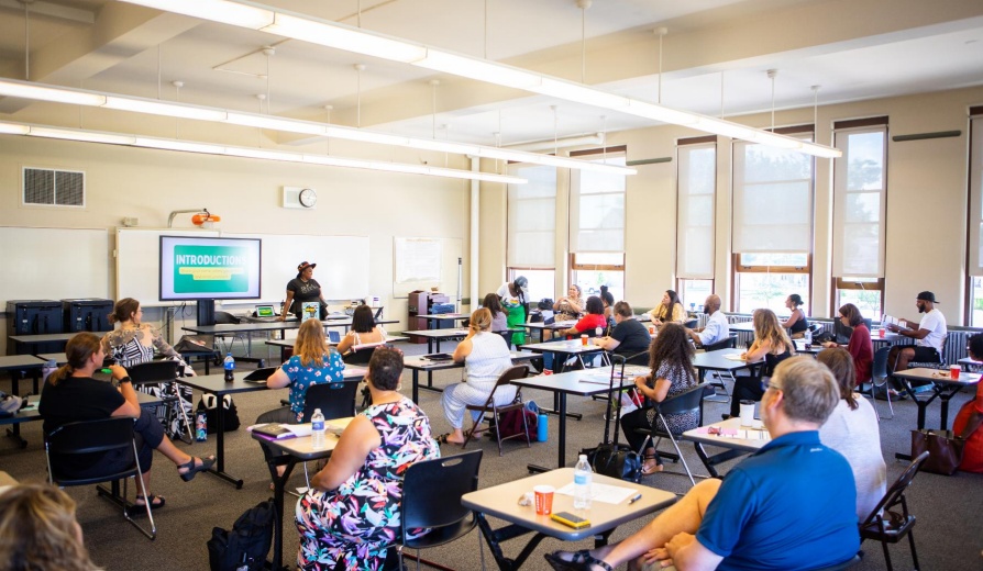 Faculty gather in a classroom for a presentation. 