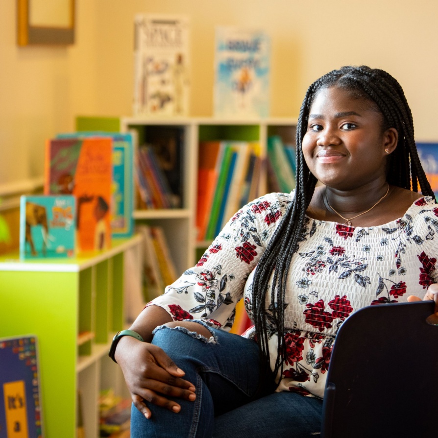 UB student intern sitting in a children's library. 