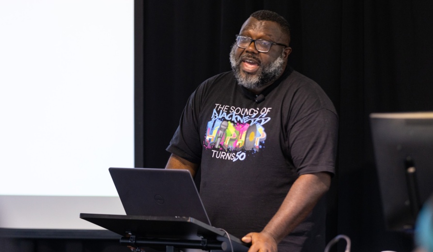 LaGarrett King teaching a class from a podium. 