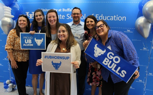 LiFTS alumni pose with UB Bulls branded signs. 