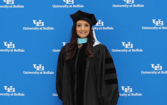 PhD student in front of step and repeat. 