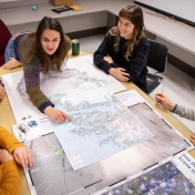 Students in Geology class pointing at a topographic map. 