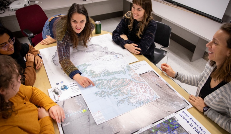 Students in Geology class pointing at a topographic map. 