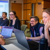 Law students working together in a classroom on laptops. 