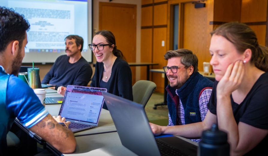 Law students working together in a classroom on laptops. 