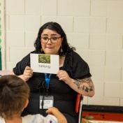 Tutor holding up a vocabularly card for a sudent. 