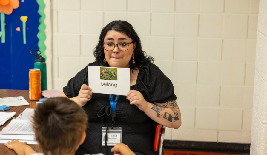 Tutor holding up a vocabularly card for a sudent. 