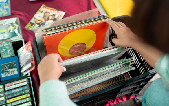 A person sorting through a box of vinyl records. 