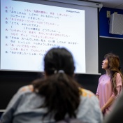 Professor teaching in front of a projected screen. 