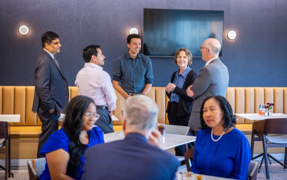 A group of UB faculty leadership and scholars gathered in a group discussion. 