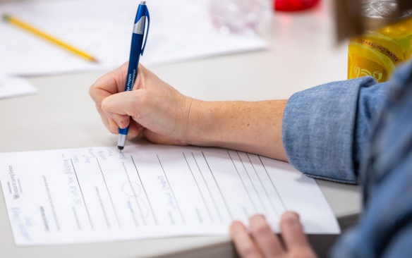 A student filling out a paper survey. 