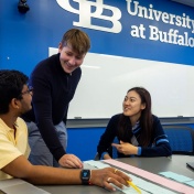 Two students engaging in a lesson with a faculty member. 