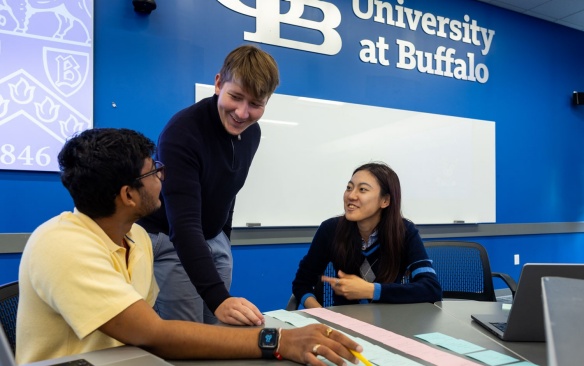 Two students engaging in a lesson with a faculty member. 