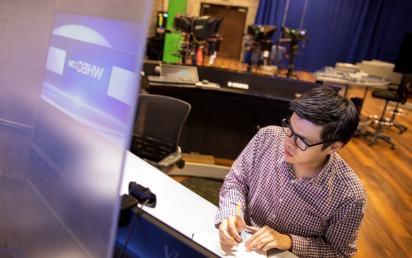 Carl Lam, with Exploratory and Pre-Professional Advising Center, also works as a local meteorologist. He is photographed in Rochesters WHEC station in July 2021. This was photographed for the feature Summer Hours, a photo series focusing on UB staff members who use the longer days to pursue interesting hobbies, causes and other endeavors outside of their day jobs.\r\rPhotographer: Meredith Forrest Kulwicki. 