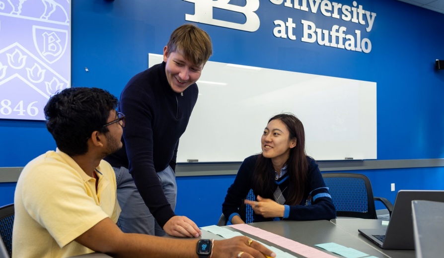 Two students engaging in a lesson with a faculty member. 