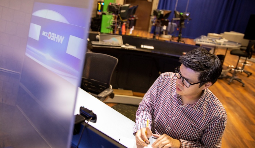 Carl Lam, with Exploratory and Pre-Professional Advising Center, also works as a local meteorologist. He is photographed in Rochesters WHEC station in July 2021. This was photographed for the feature Summer Hours, a photo series focusing on UB staff members who use the longer days to pursue interesting hobbies, causes and other endeavors outside of their day jobs.\r\rPhotographer: Meredith Forrest Kulwicki. 