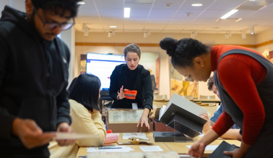 Librarian Archivist working with students and a collection in a library on UB's North Campus. 