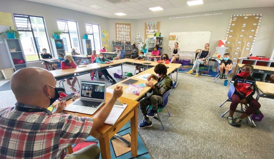 Rob Martin, EdM ’01, leads a 4th-grade class as he interviews a photojournalist by Zoom at the American International School of Lusaka in Zambia, March 2020. (Photo/Tony Potts). 