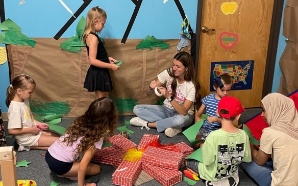 Teacher in an early childhood classroom with students. 