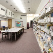 A wall full of books and a few tables for tutoring. 