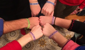 Alberti Center team members with fists together in circle. 