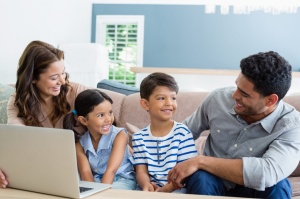 two parents with their children and computer. 