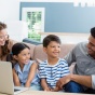 two parents with their children and computer. 