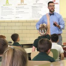 Image of grad student presenting at elementary school. 