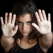 Female child with hands up signaling stop. 