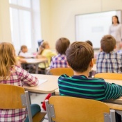 Young children sitting in a classroom. 