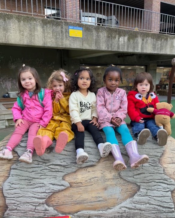 ECRC students sitting in a group at the playground. 