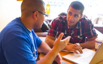 Two students meeting at a laptop. 
