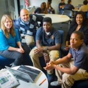 Nathan J. Daun-Barnett with students working on FAFSA project around computer. 